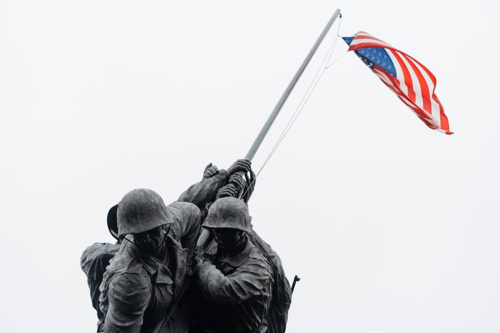 a-couple-of-soldiers-holding-a-flag-on-top-of-a-hill-al9bgurro8m
